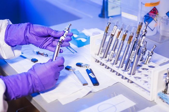 Someone in research lab with gloves and vaping devices