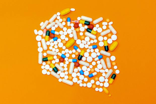multi-colored pills on an orange background
