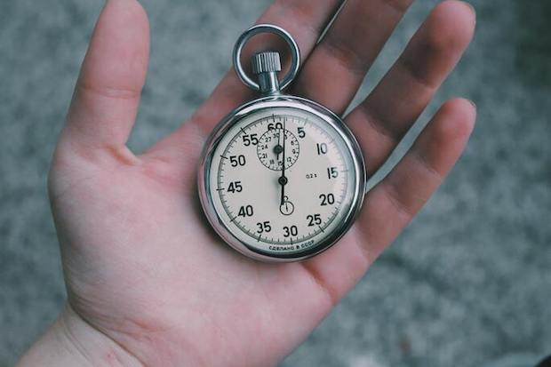 A hand holding a pocket watch