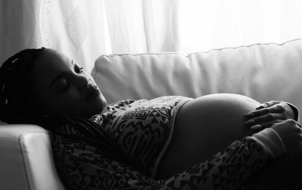 a pregnant woman lying on a couch