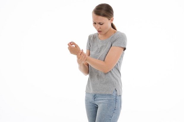 a woman holding her wrist in pain